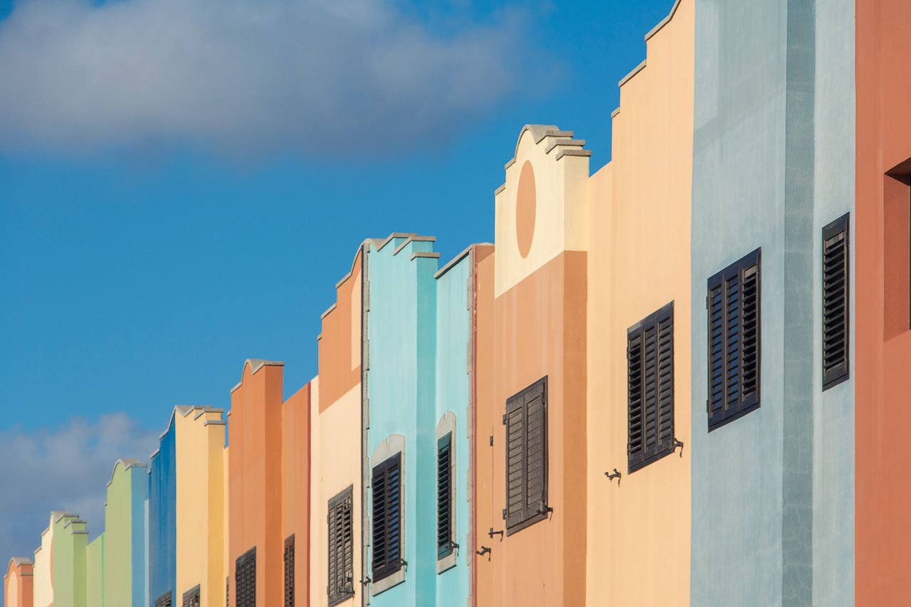 Vibrant multicolored facades of Caribbean-style buildings under a clear blue sky.